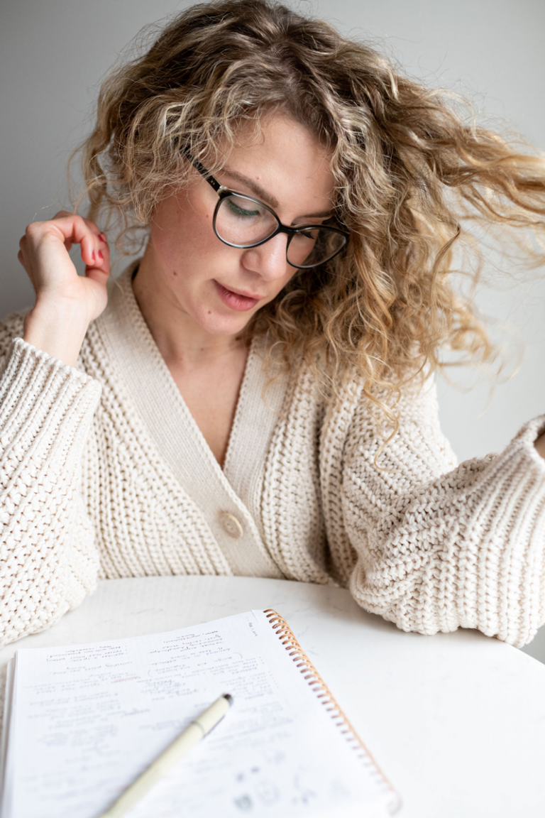 Portrait of writer at table, glasses, slow fashion, ethical clothing for women, ethical sweaters, upcycled fashion, ethical branding, brand voice, storytelling, narrative aesthetic, outdoors, conscious consumer, advice for creatives, advice for bloggers, Content Creation, social media strategy and coordination, ongoing blog content, ghostwriting for designers and creatives, adventurers and explorers, newsletter content, email newsletters, print marketing materials, Creativity, Clarity, Connection, Loyalty, Communication, Go-Getter Mindset, Collaboration, Proactivity, Enthusiasm, Transparency, Open-Minded Curiosity, Engaging, Efficiency, Business, Architecture, Design, collaboration, writing style, entrepreneur, female empowerment, Homey, Engaging, Rooted, Warm, Insightful, Organized, Clever, Thoughtful, Positive, Inspiring, young visual creative entrepreneurs passionate about spaces, customers and communities, Copywriting Outdoor Industries, Copywriting Northern MN, Interior Design Content Writer, Creative, Editor, Content Creator and Social Media Strategist, Books, Empowerment, business, women in business, how to be a fulltime creative, articles, solopreneur, social media, creative, creatives, natural, starting out, tips, entrepreneur, alignment, slow lifestyle, minimalism, minimal, declutter, make space, space, create room, unique, portrait, self portrait, white, clean room, interior design